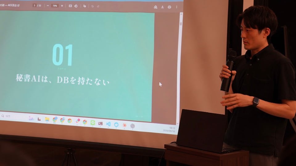 スクリーンにスライドを映し、マイクを持って話す当社代表